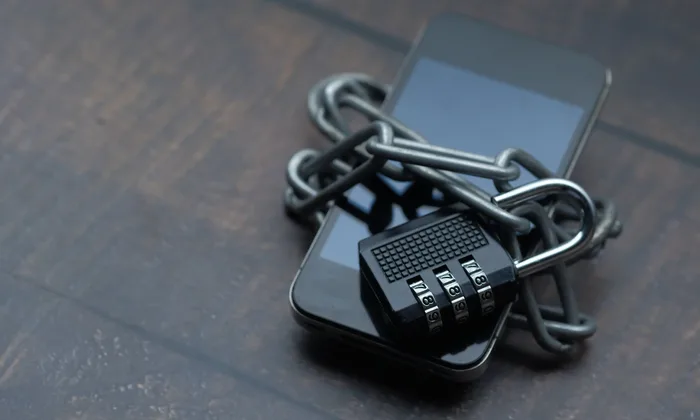 Smartphone wrapped in a chain with a padlock, representing JustForFans and LoyalFans leak removal